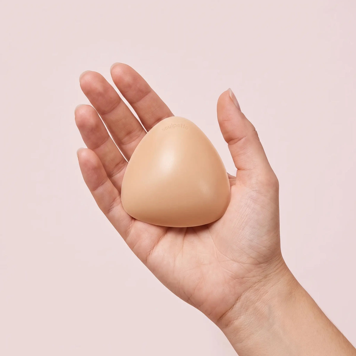 The Sculpt Petite insert on an open hand, clearly smaller than the palm