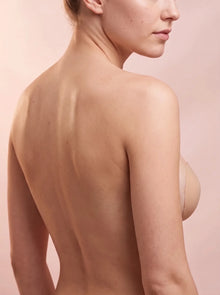 The Invisible Bra worn backless: bare back, the cup visible only at the side of the breast