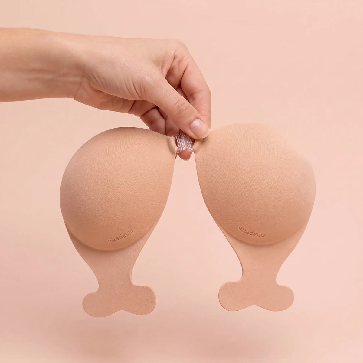 The Statement Bra held up by its clasp to show the cup size
