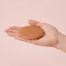 The Sculpt Round cover in Caramel on an open hand to show its true size