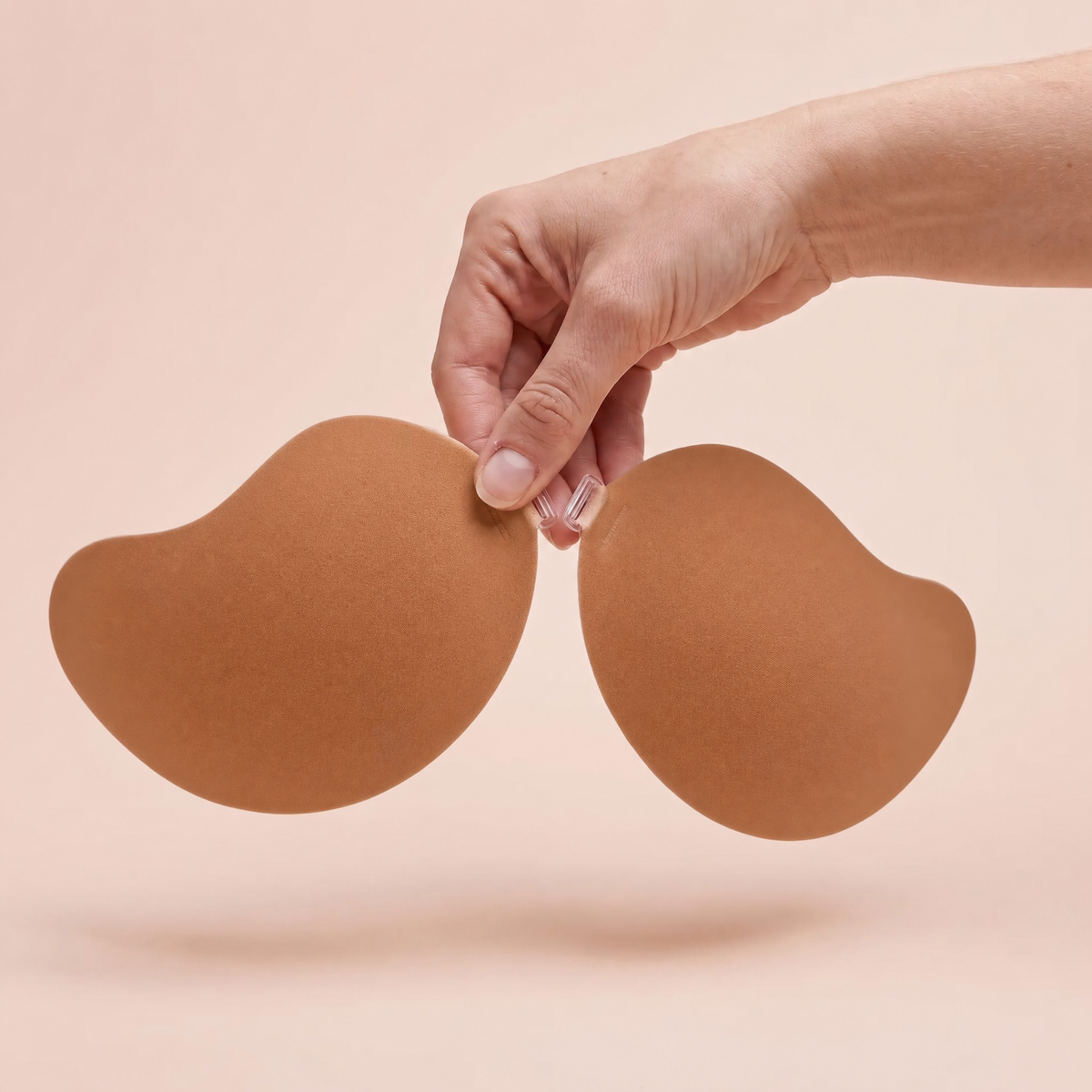 The Invisible Bra in Caramel held up by its clasp to show the size of the cups