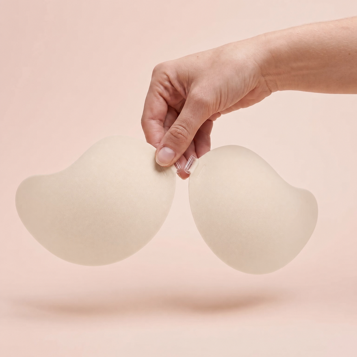 The Invisible Bra in Porcelain held up by its clasp to show the size of the cups