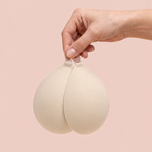The Sticky Bra in Porcelain held up by its clasp to show the size of the cups