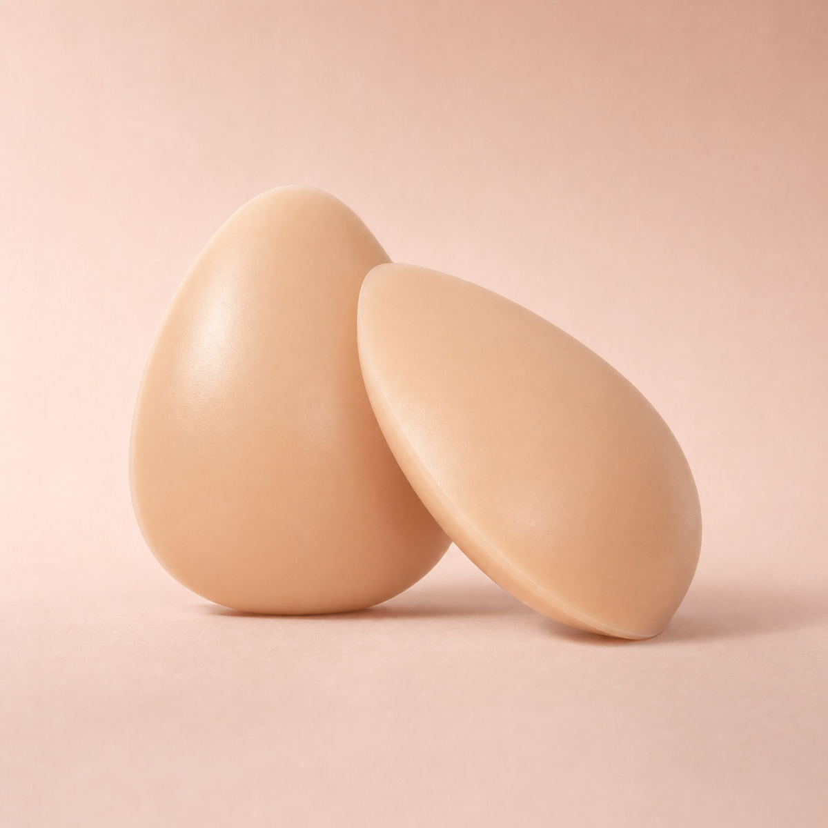 A pair of The Sculpt adhesive bra inserts in Nude, one upright and one leaning to show the profile