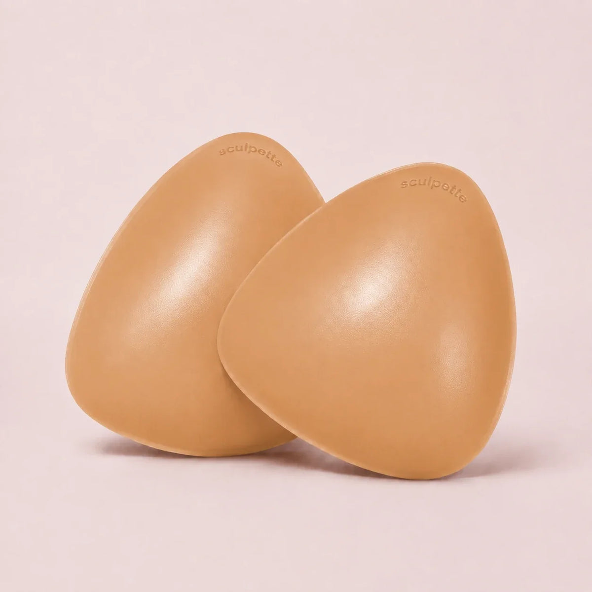 A pair of The Sculpt adhesive bra inserts in Honey standing side by side