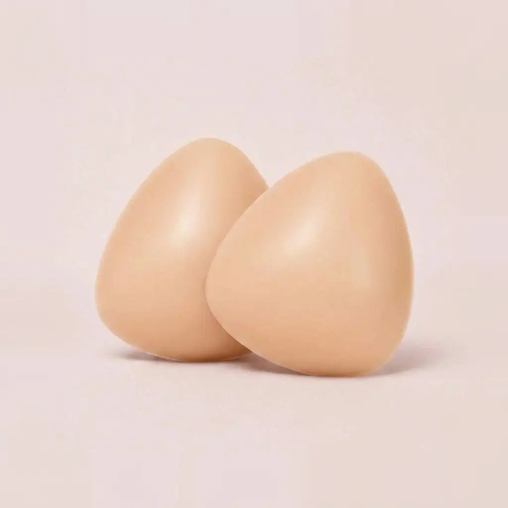 A pair of The Sculpt adhesive bra inserts in Nude standing side by side
